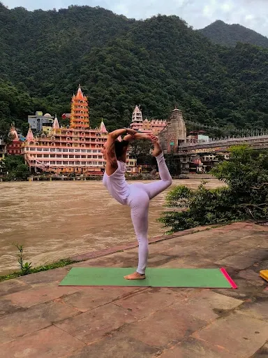 Laura nella posizione del danzatore, Natarajasana, sulla riva del Gange a Rishikesh