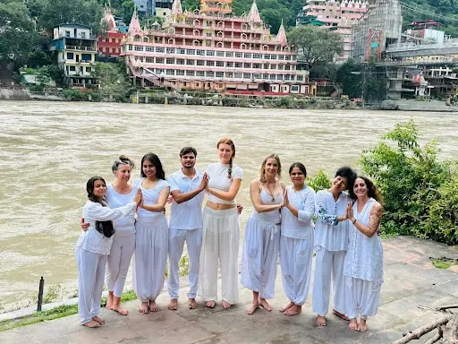 Gli allievi della scuola di Jitendra Das vestiti di bianco sulla riva del Gange a Rishikesh