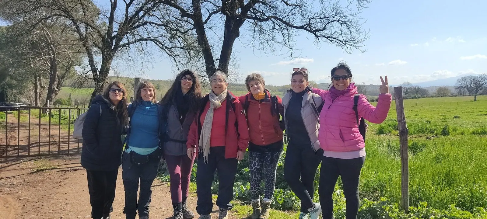 Il gruppo sorridente in posa davanti a un cancello di legno, fra i prati verdi della Maremma