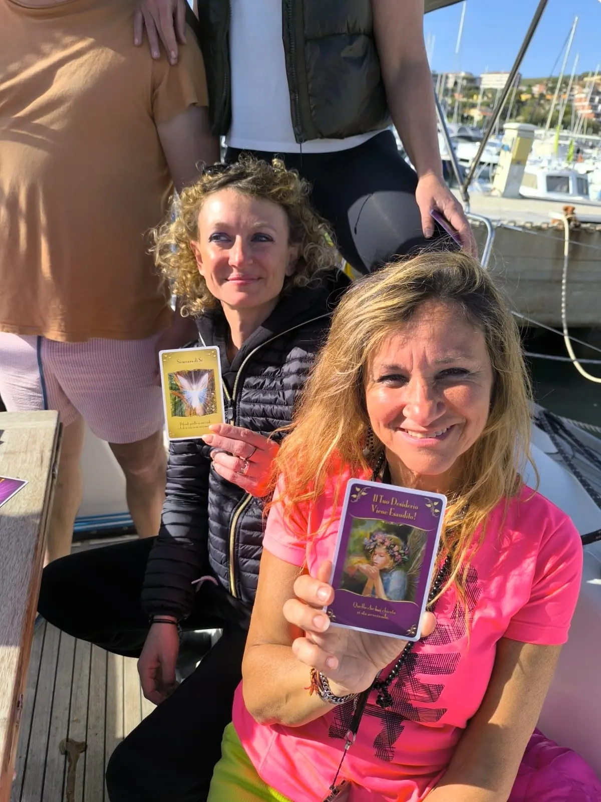 Due partecipanti a bordo mostrano le loro carte