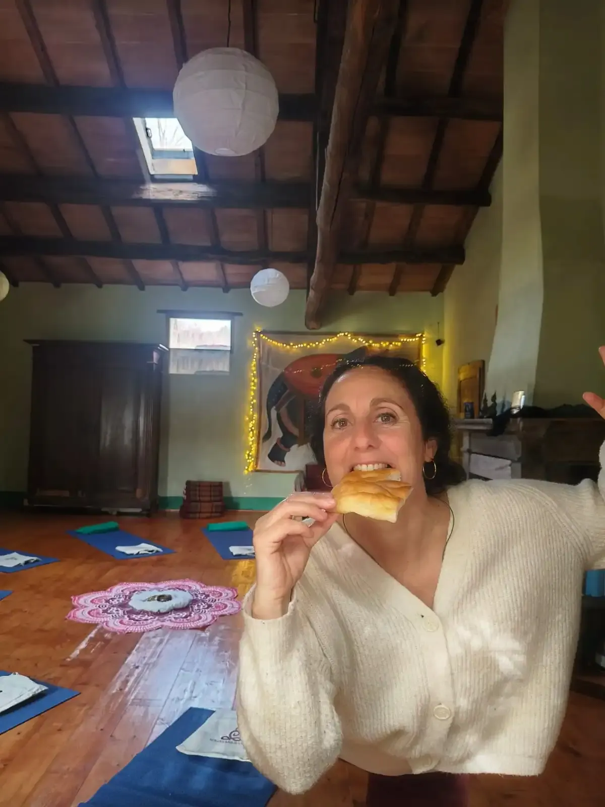 Una partecipante sorride assaggiando un dolce nella sala della pratica