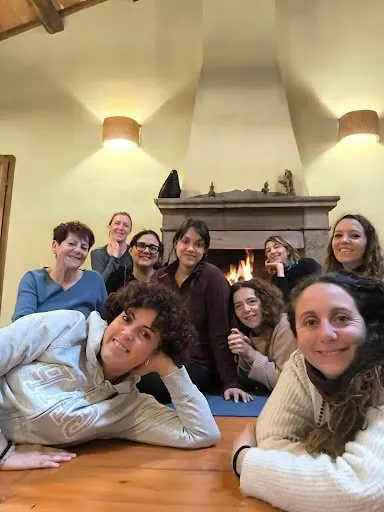 Le partecipanti sorridenti sdraiate davanti al camino acceso