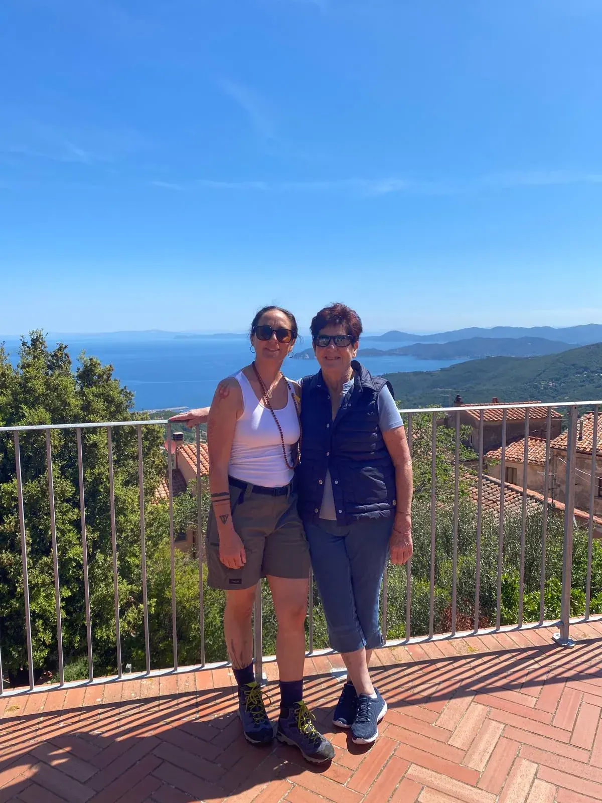 Due amiche su una terrazza affacciata sul mare e sulla macchia