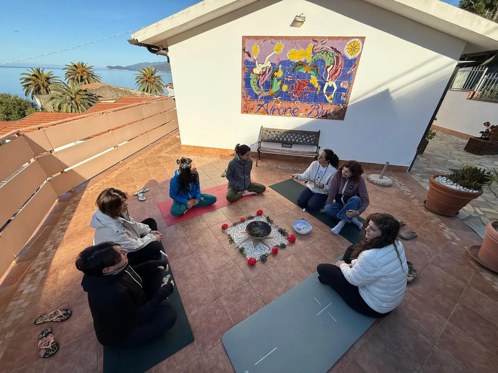 Il cerchio delle partecipanti su una terrazza con vista sul mare