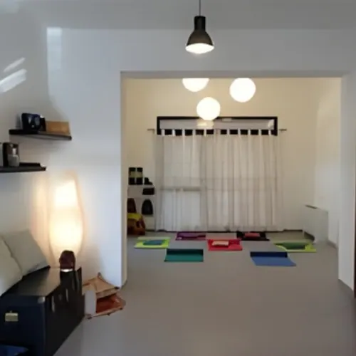 Una sala di YogaSankranti con i tappetini colorati pronti per la lezione e le luci accese