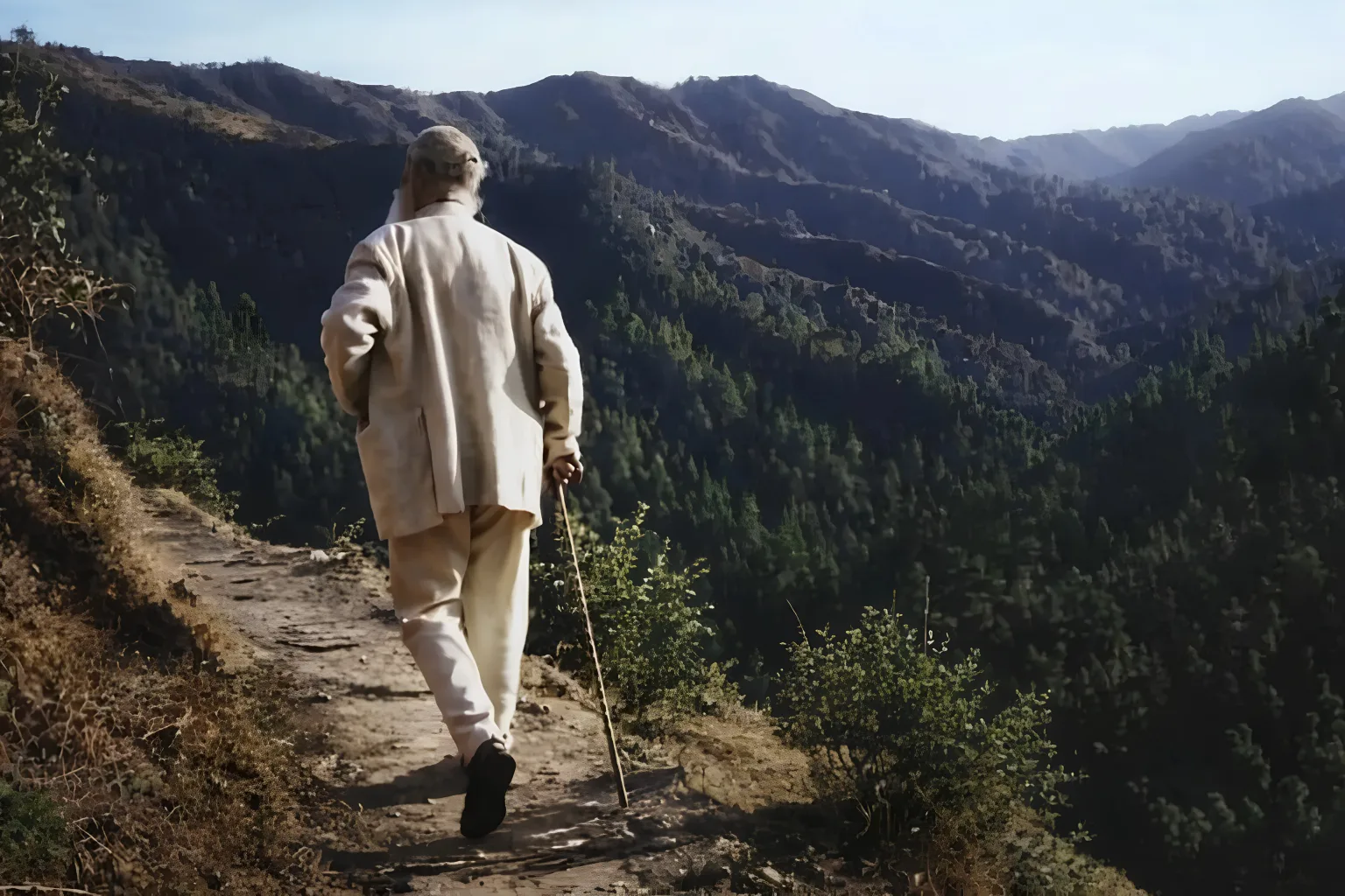 Tiziano Terzani di spalle, in cammino su un sentiero di montagna nella valle dell'Orsigna